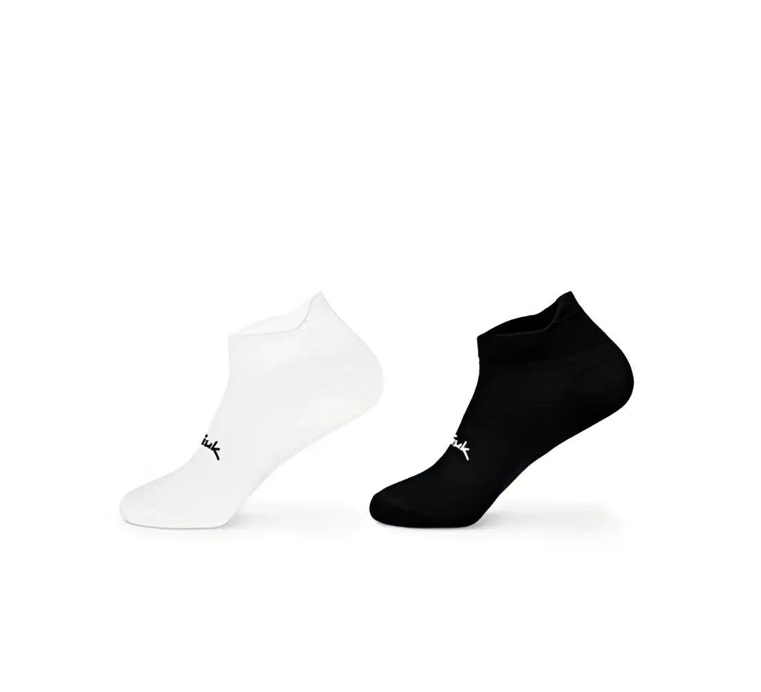 Un par de calcetines ankle ciclismo spiuk anatomic micro blanco y negro con logo bordado cerca del talon